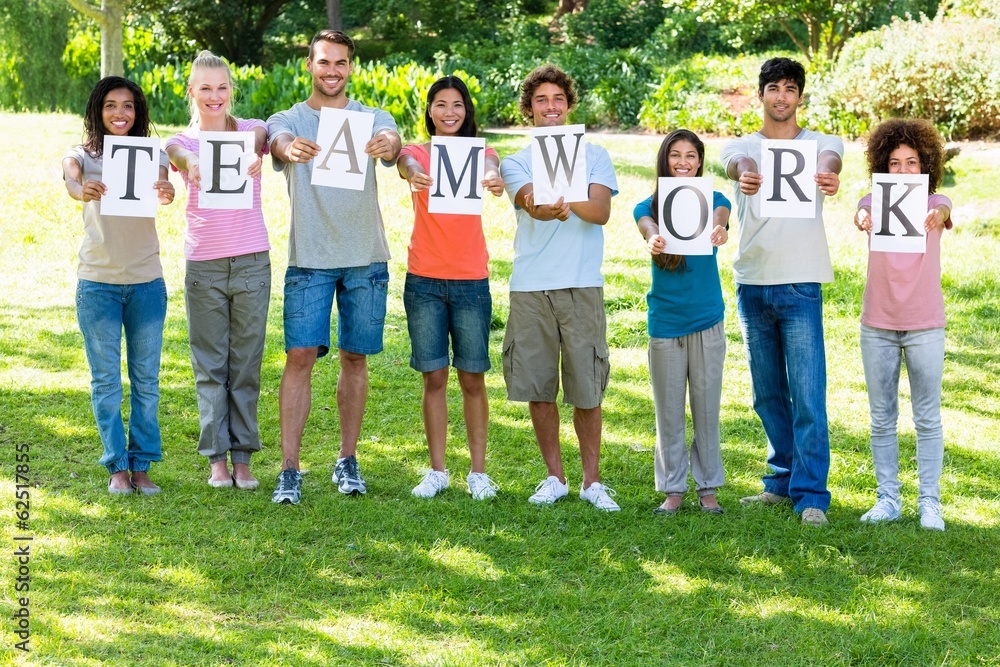 Friends holding placards reading teamwork Friends holding placards reading teamwork