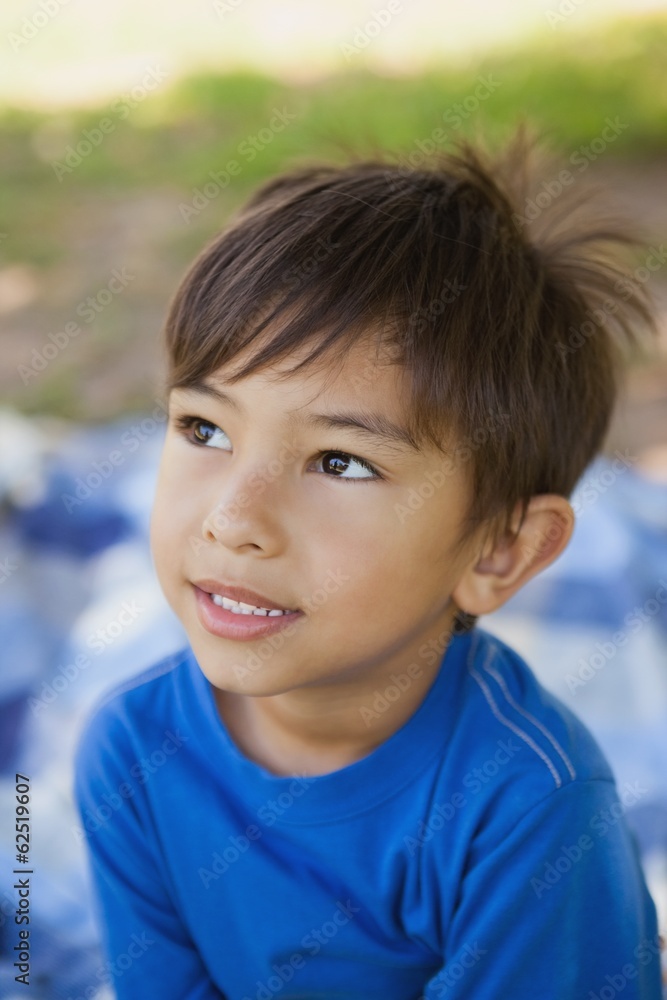 Boy looking away in thought at park Boy looking away in thought at park