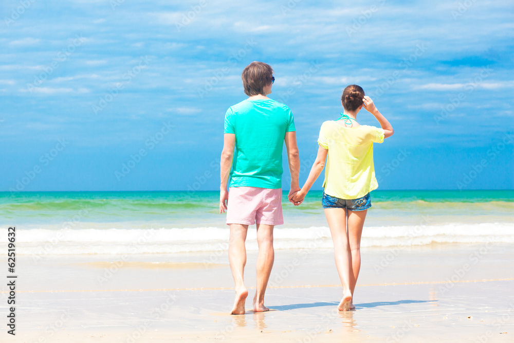 Couple in bright clothes on tropical beach in Thailand