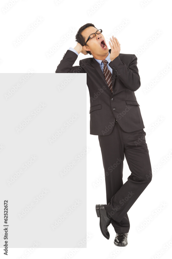 businessman yawning and standing with blank board businessman yawning and standing with blank board