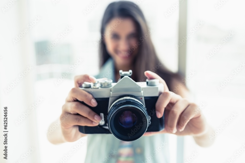 Stylish young woman taking a photo at camera Stylish young woman taking a photo at camera