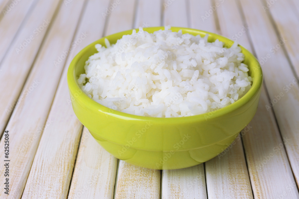Cooked rice in bowl on wooden background Cooked rice in bowl on wooden background