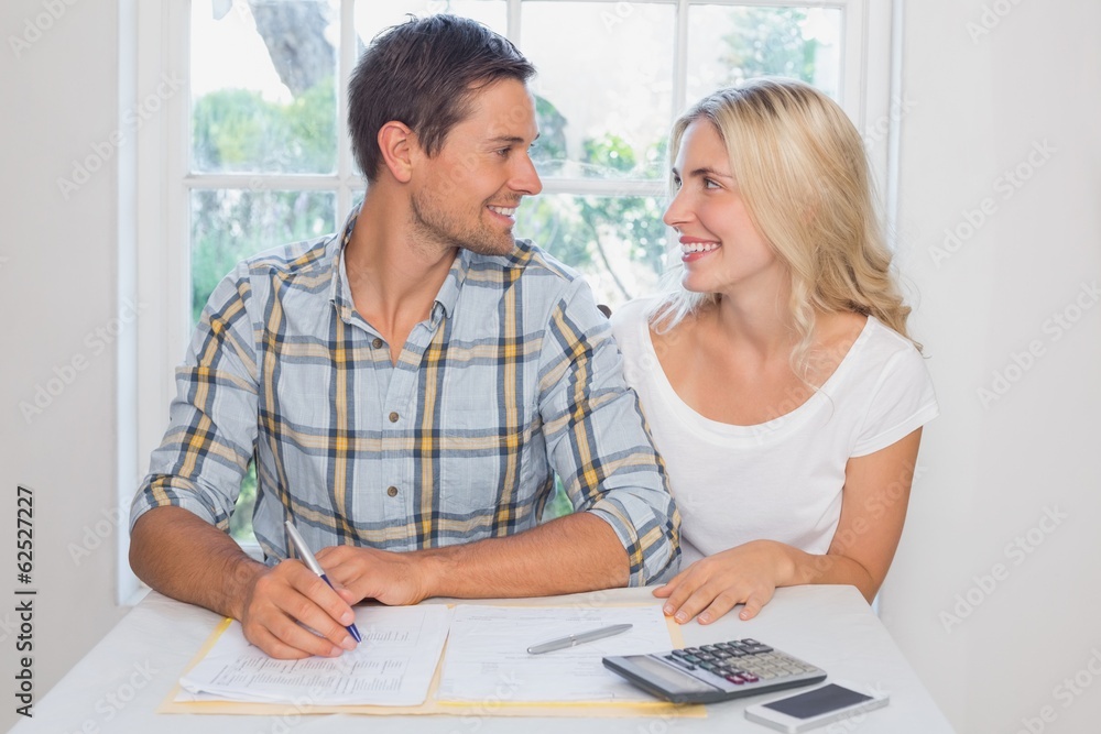 Couple with financial documents and calculator at home