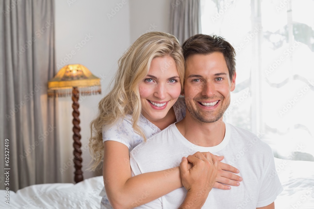 Loving woman embracing man from behind at home Loving woman embracing man from behind at home
