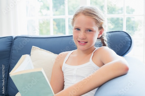 Relaxed girl reading book on sofa in living room Free Download Relaxed girl reading book on sofa in living room - GFXLoad