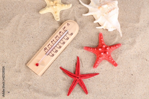 Thermometer on sand background
