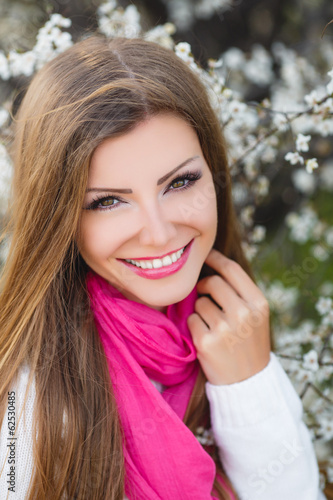 portrait of young brunette in the spring blooming garden