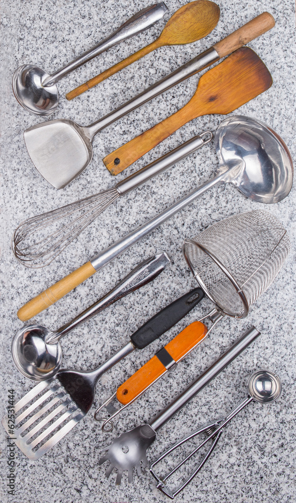 A collection of kitchen utensil on granite surface A collection of kitchen utensil on granite surface