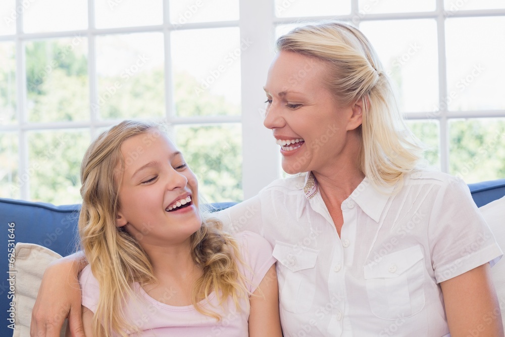 Mother and daughter laughing on sofa Mother and daughter laughing on sofa