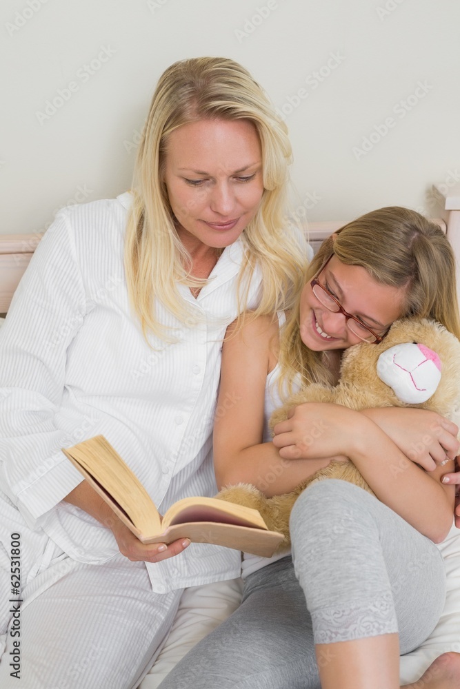 © lightwavemedia - Mother and daughter reading story book in bed © lightwavemedia - Mother and daughter reading story book in bed