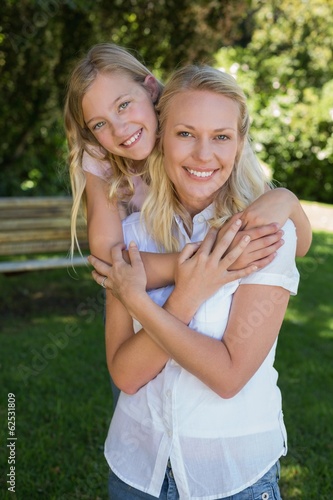 Girl embracing mother from behind in park