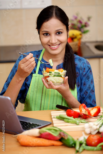 Young Indian woman eating salad