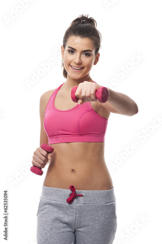 Woman with dumbbells while hard workout