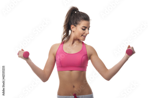 Focus young woman lifting dumbbells
