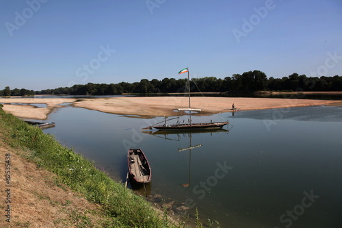 Pêcheur sur un banc de sable - embarcations au repos.
