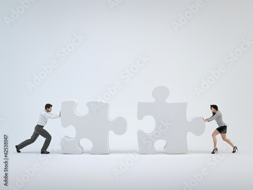 Teamwork, woman and man pushing toward each other puzzle