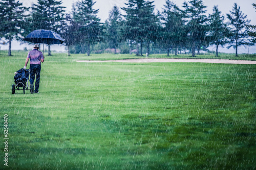 Golfer on a Rainy Day Leaving the Golf Course