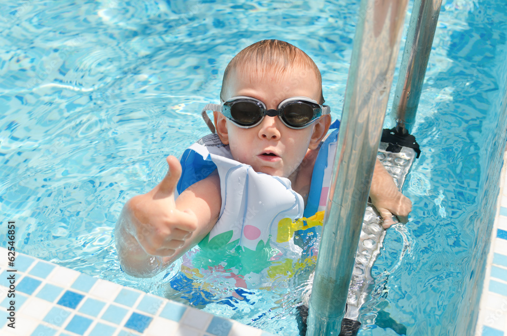 Young boy in a swimming pool giving a thumbs up Stock Photo | Adobe Stock