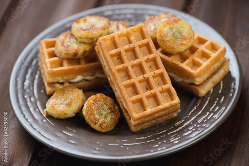 Waffles with fried banana on a glass plate, studio shot