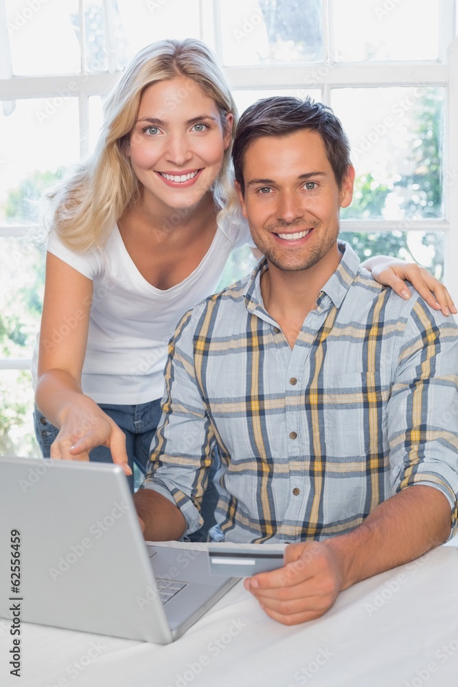 Smiling young couple doing online shopping at home Smiling young couple doing online shopping at home