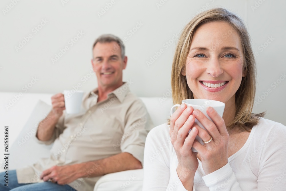 Relaxed couple with coffee cups in living room Relaxed couple with coffee cups in living room