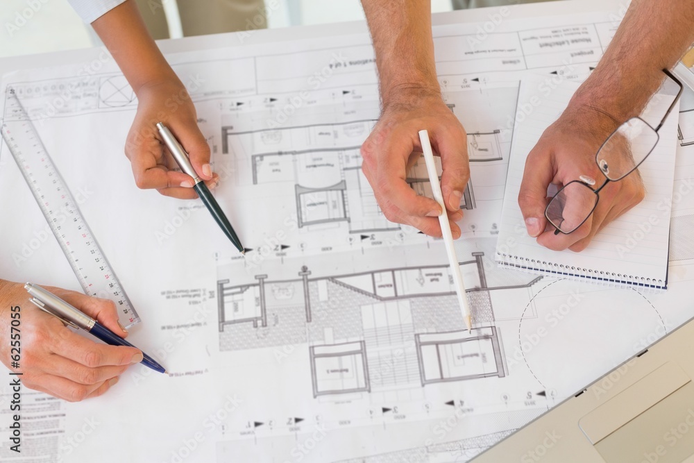 Several hands working on blueprints Several hands working on blueprints