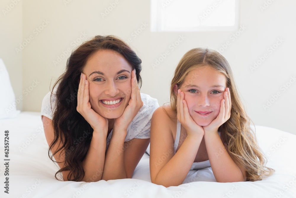 Mother and daughter with head in hands on bed Mother and daughter with head in hands on bed