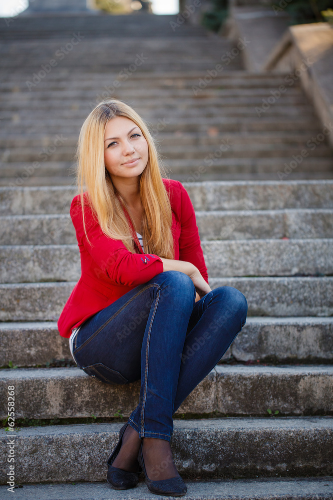 young woman sitting on the stairs of office building young woman sitting on the stairs of office building