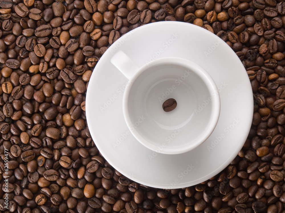 A white cup with one coffee bean on beans background