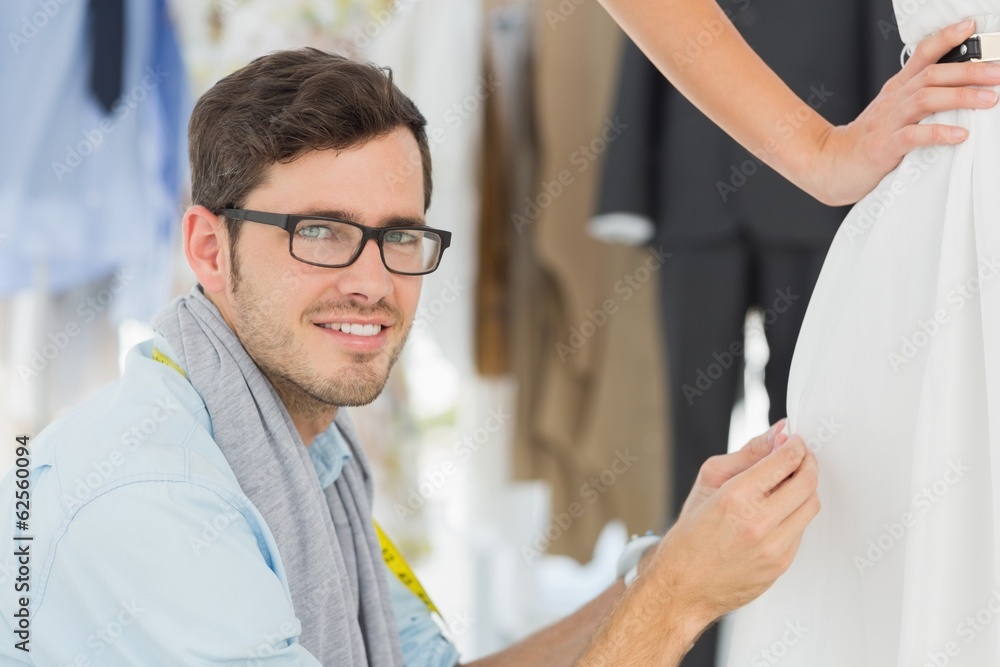 Male fashion designer adjusting dress on model Male fashion designer adjusting dress on model
