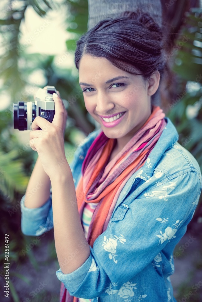 Cheerful brunette taking a photo outside smiling at camera