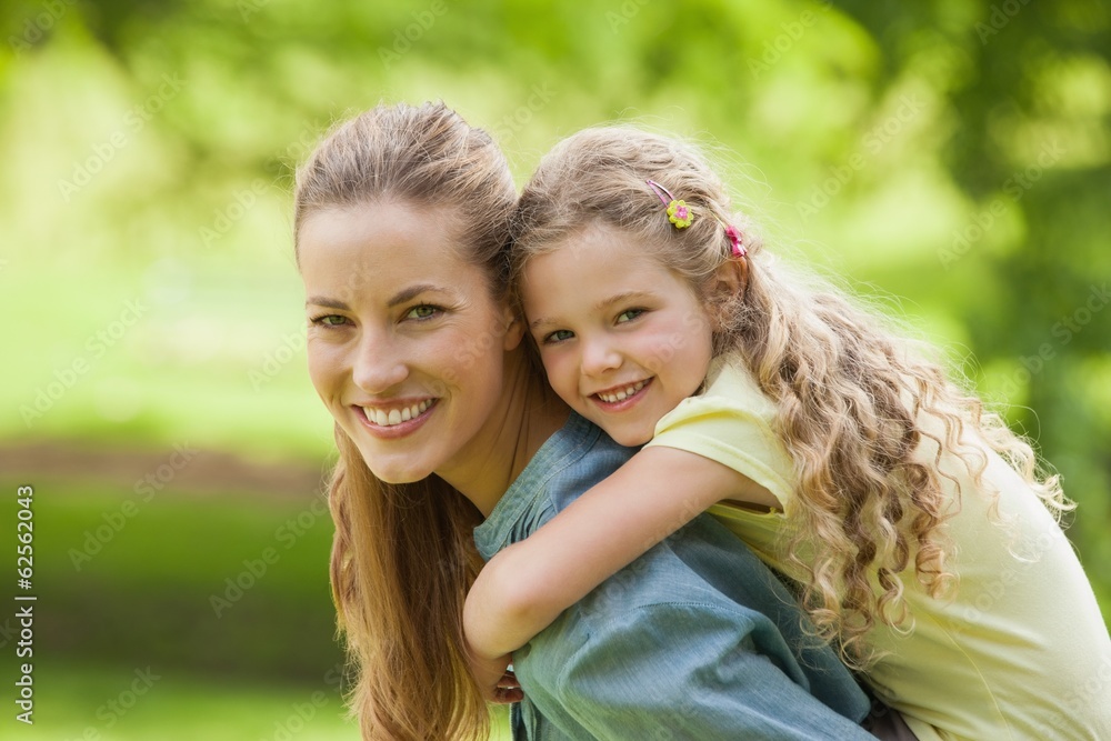 Side view of a woman carrying girl at park Side view of a woman carrying girl at park