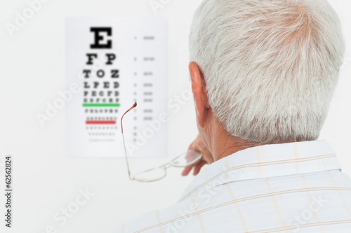 Fototapeta Naklejka Na Ścianę i Meble -  Rear view of a senior man looking at eye chart
