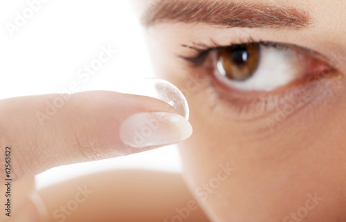 Fototapeta Naklejka Na Ścianę i Meble -  Woman putting contact lens in her eye