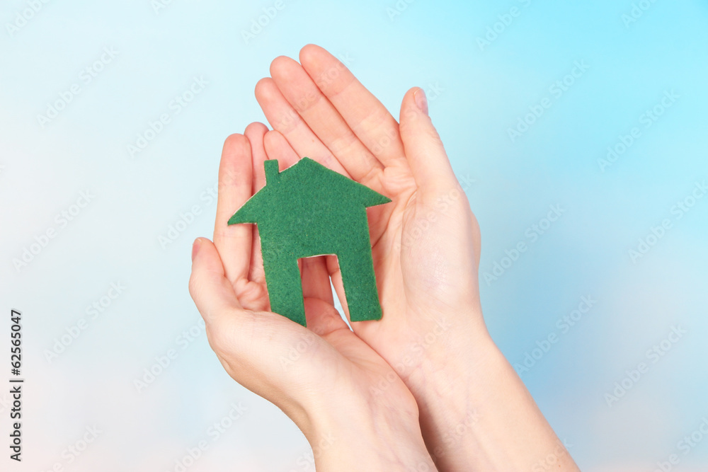 Little paper house in hand close-up, on light background Little paper house in hand close-up, on light background