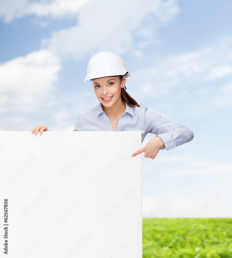businesswoman in helmet pointing finger to board businesswoman in helmet pointing finger to board