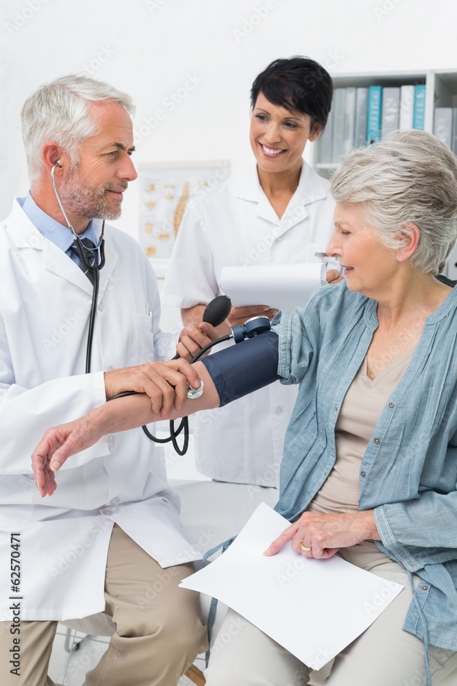 Fototapeta premium Doctor measuring blood pressure of a senior patient