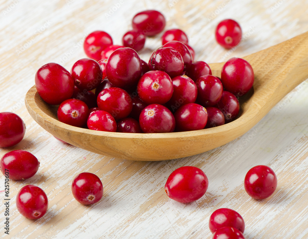 Cranberries in a wooden spoon Cranberries in a wooden spoon