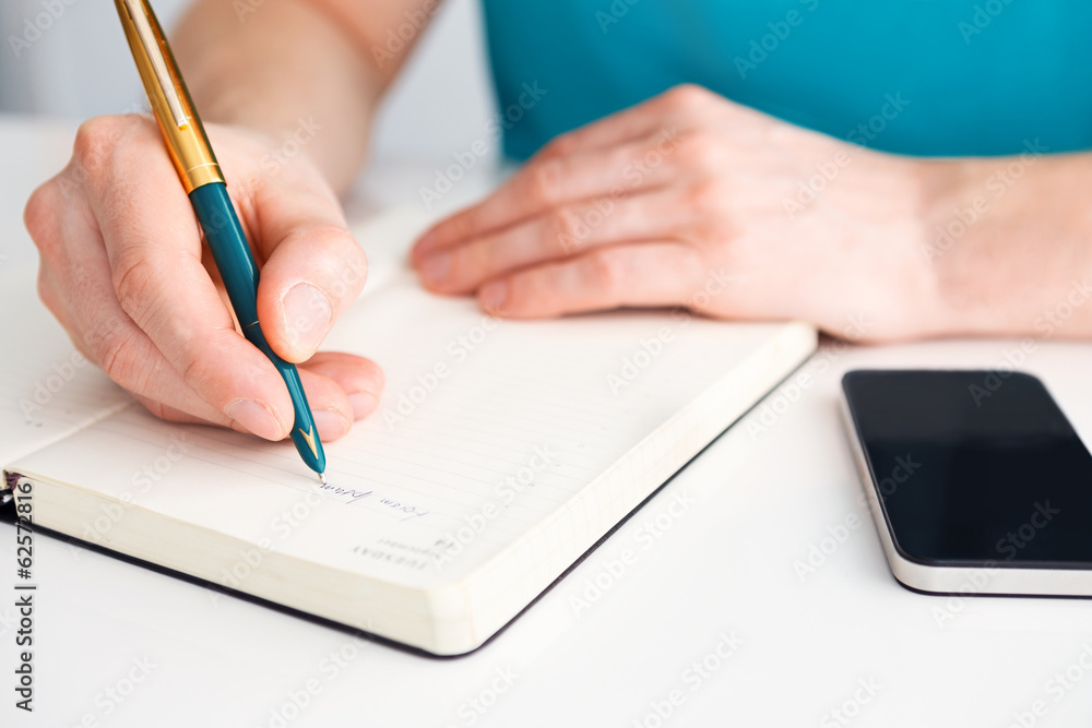 Man's hand writes a pen on diary Man's hand writes a pen on diary