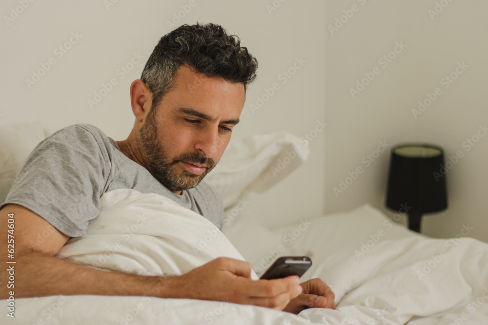 men in bed use his smartphone men in bed use his smartphone
