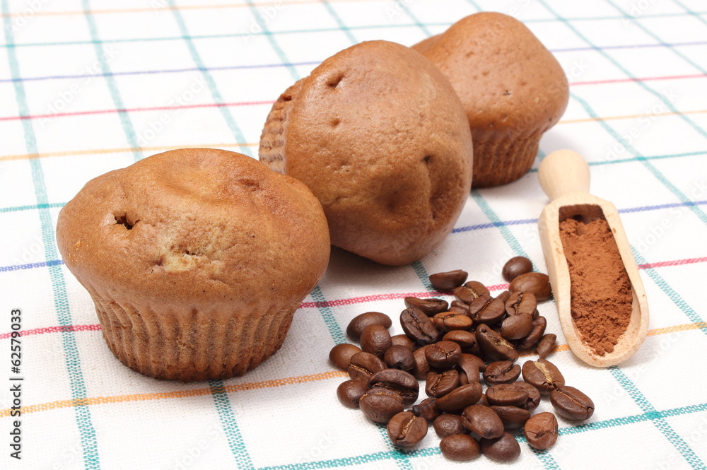 Fresh baked muffins, coffee grains and powdery cinnamon Fresh baked muffins, coffee grains and powdery cinnamon
