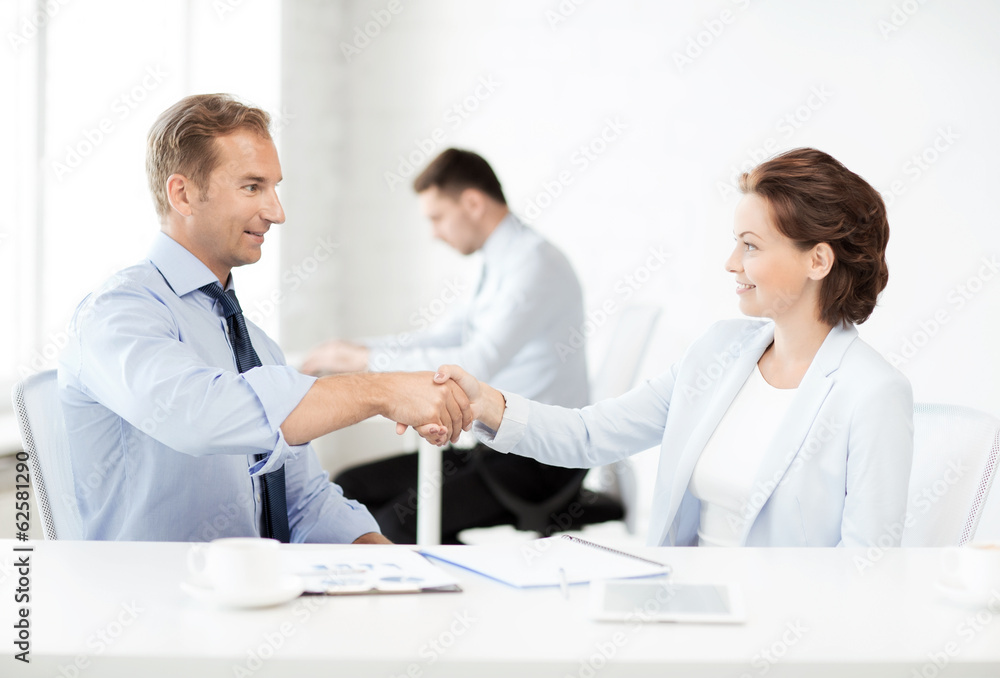 man and woman shaking hands in office man and woman shaking hands in office