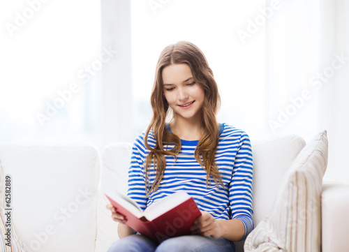smiling teenage girl reading book on couch Free Download smiling teenage girl reading book on couch - GFXLoad