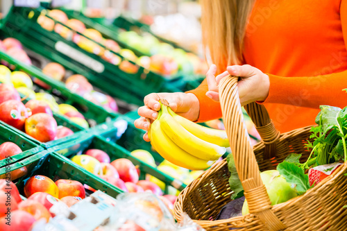 Frau im Supermarkt kauft Obst und Lebensmittel