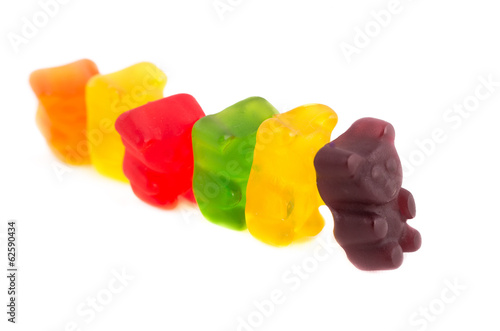 Row of colorful gummy bears on isolated white background photo