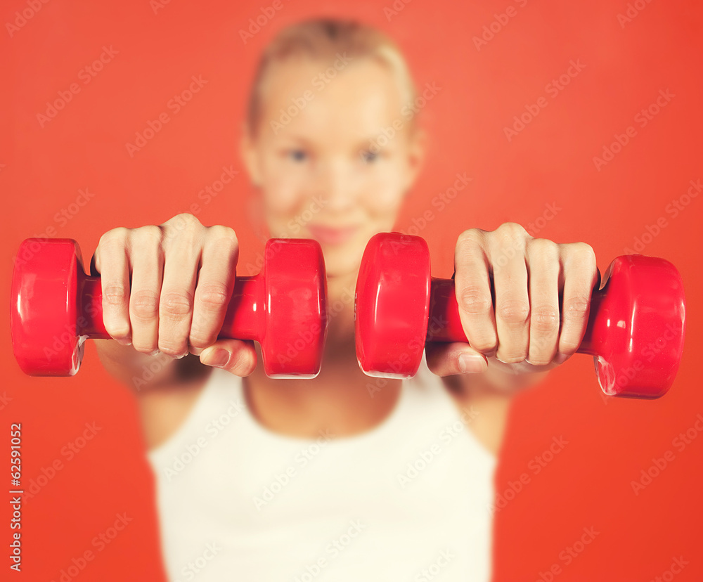 Smiling woman with two red weights