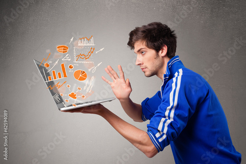 Handsome man holding laptop with graphs and statistics