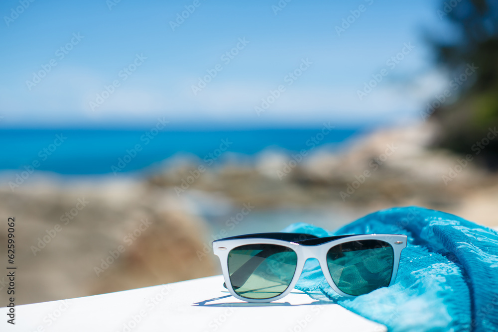 summer concept with sunglasses and seashell on sand
