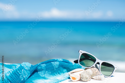 summer concept with sunglasses and seashell on sand