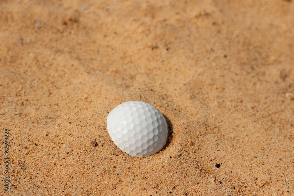 Golf ball in sand on bunker golf course Golf ball in sand on bunker golf course